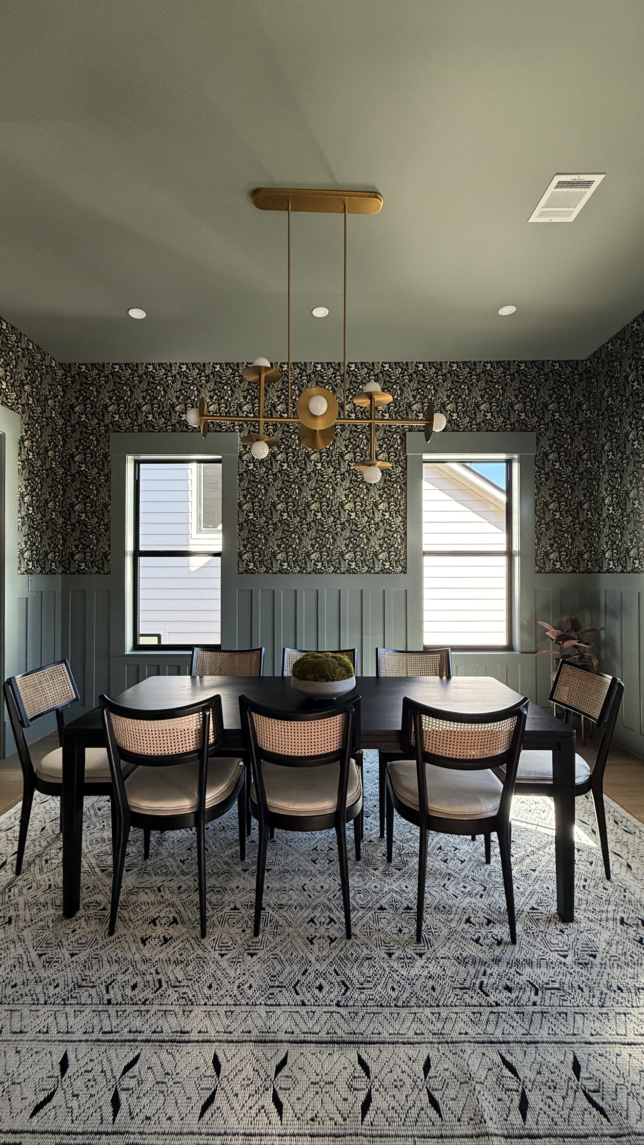 Dark botanical wallpaper installed in an elegant dining room