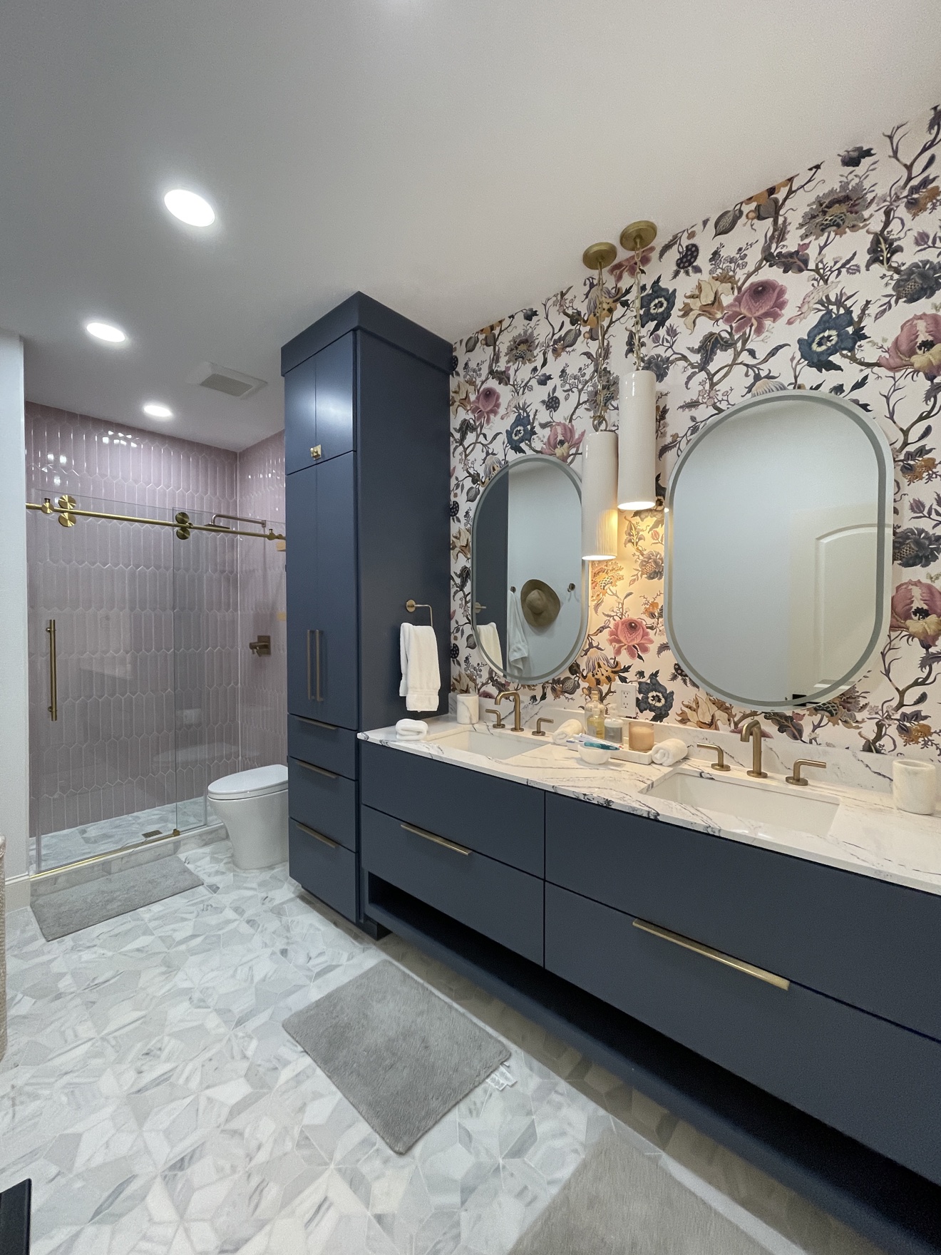 Colorful floral wallpaper installed above a finished double vanity with mirrors