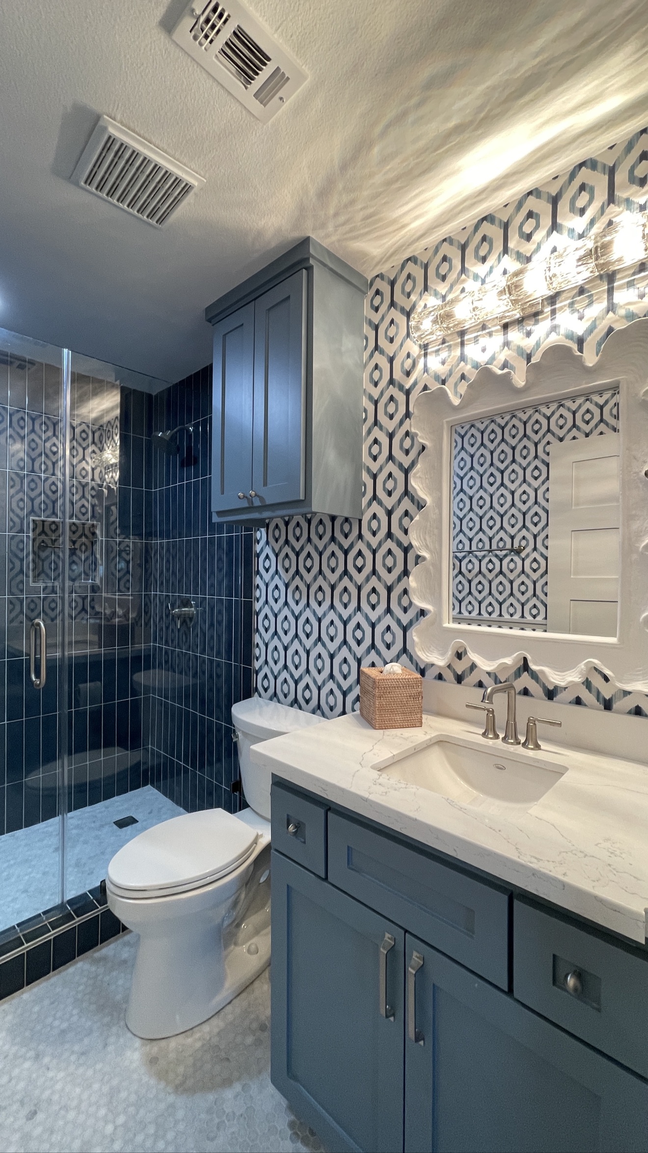 Blue geometric wallpaper installed around a bathroom vanity