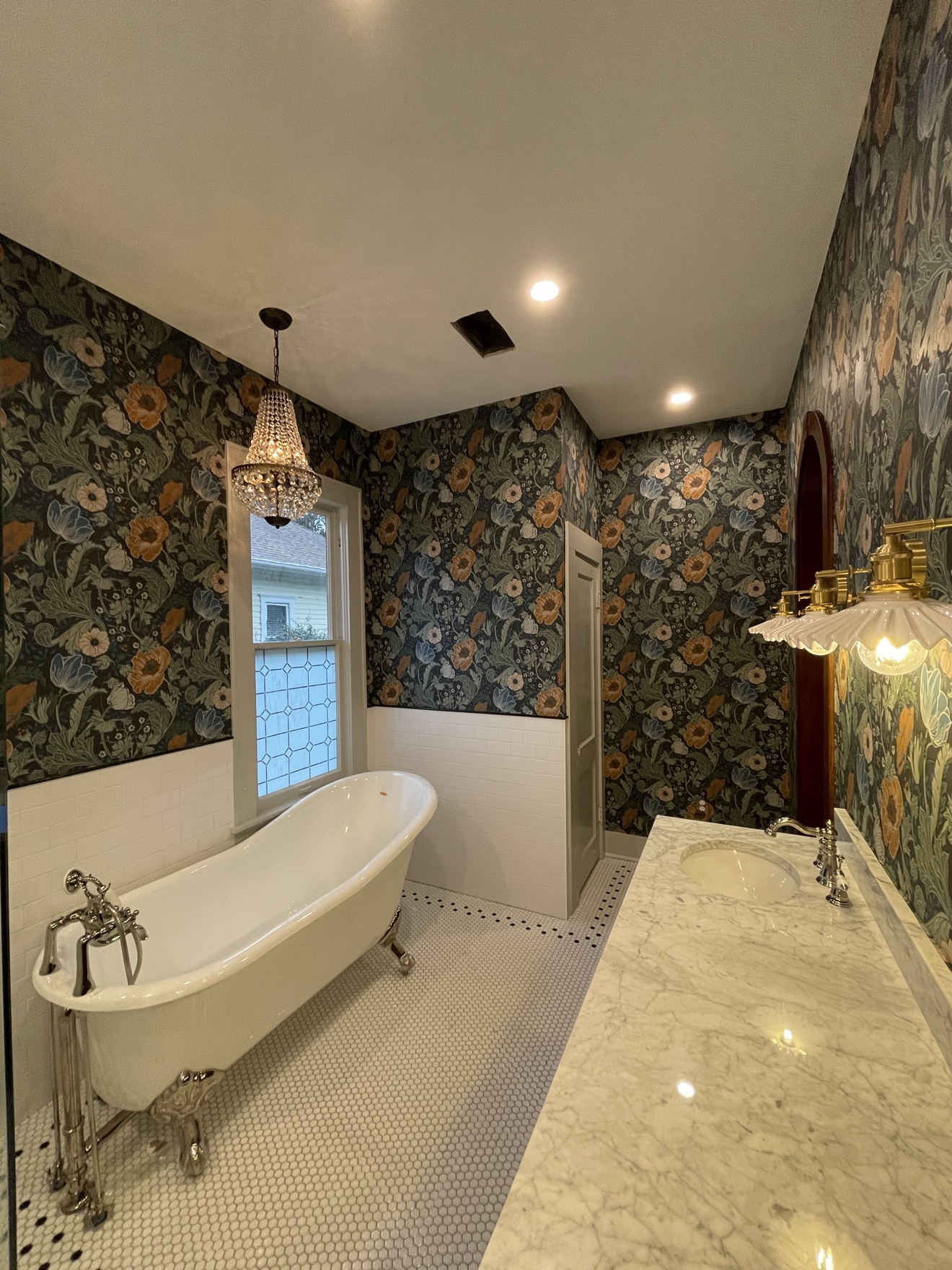 Dark floral wallpaper surrounding a clawfoot tub