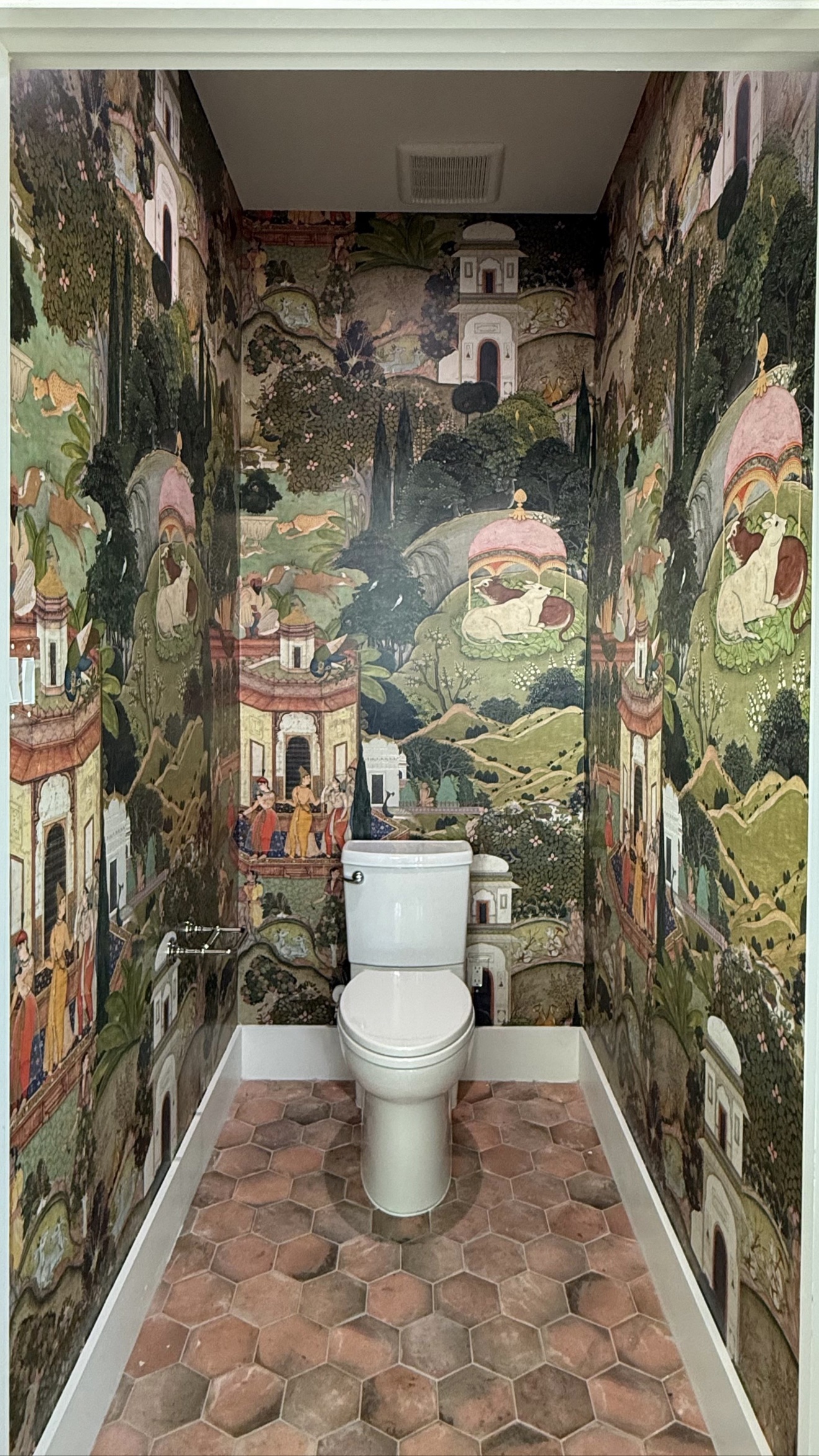 Detailed scenic mural wallpaper installed throughout a powder room