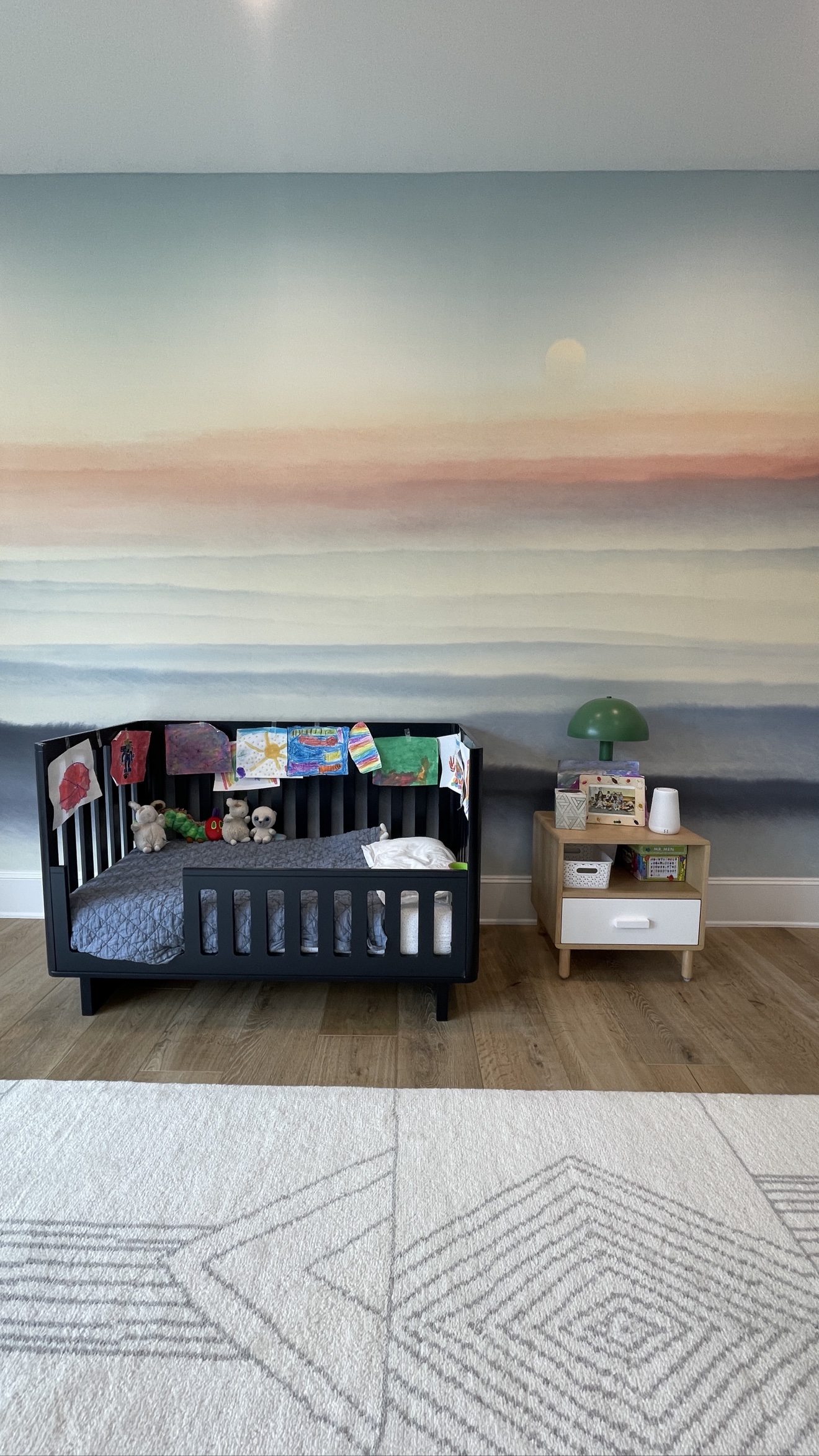 Soft watercolor landscape mural installed in a nursery