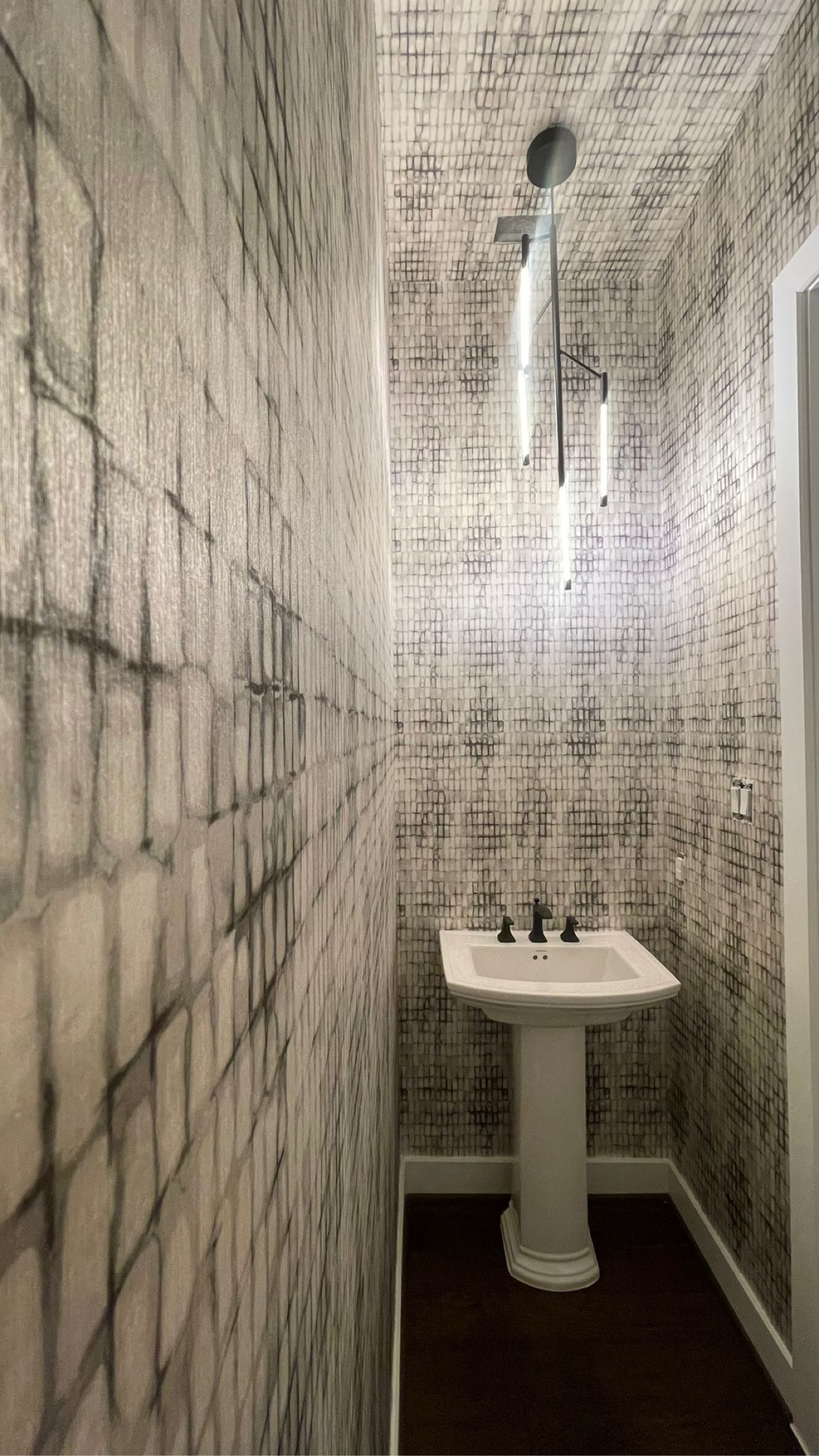 Black and white abstract wallcovering installed on the walls and ceiling of a powder room